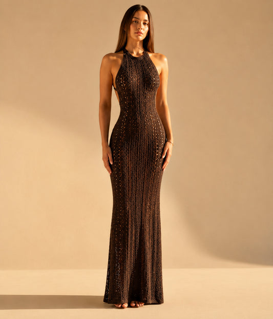 Woman wearing a long, dark brown evening gown with intricate detailing against a beige background